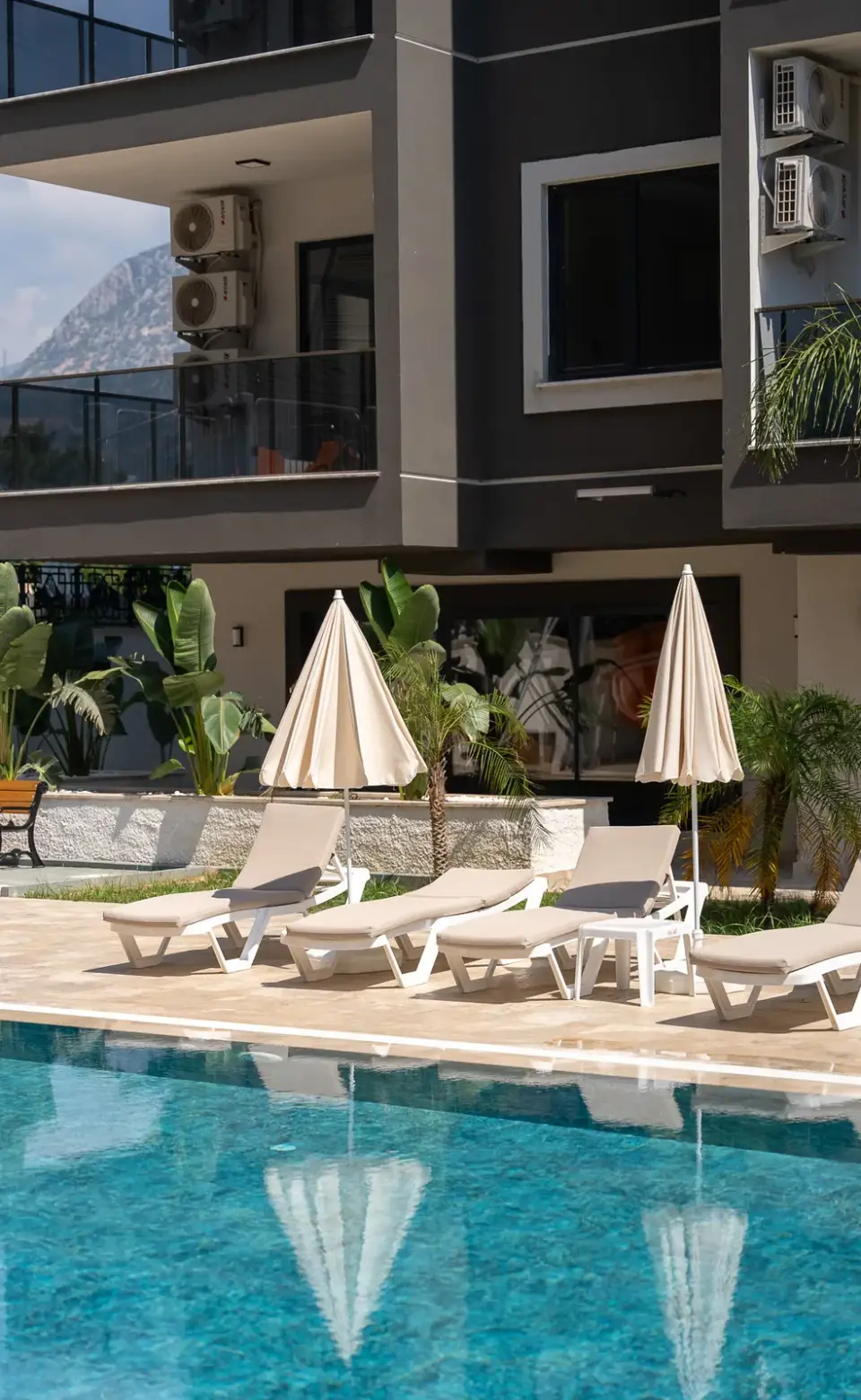 Sun loungers by the pool below the building facade