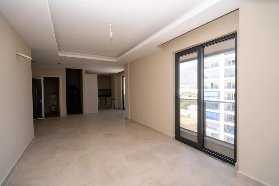 A living room with a balcony door and a view of the mountains